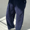 side view of model wearing navy corduroy arc pants with side panels and pockets