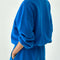 back view of model wearing lagoon blue pull over sweatshirt with slight balloon sleeve and waist band