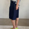 side view of model wearing dark blue bermuda shorts with side pockets