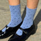 side view of model wearing blue socks with navy polka dots