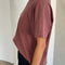 side view of model wearing relaxed, slightly cropped brick tee with distressing on the neckline