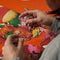 model putting together 500 piece puzzle with realistic colorful retro inflatables piled on each other