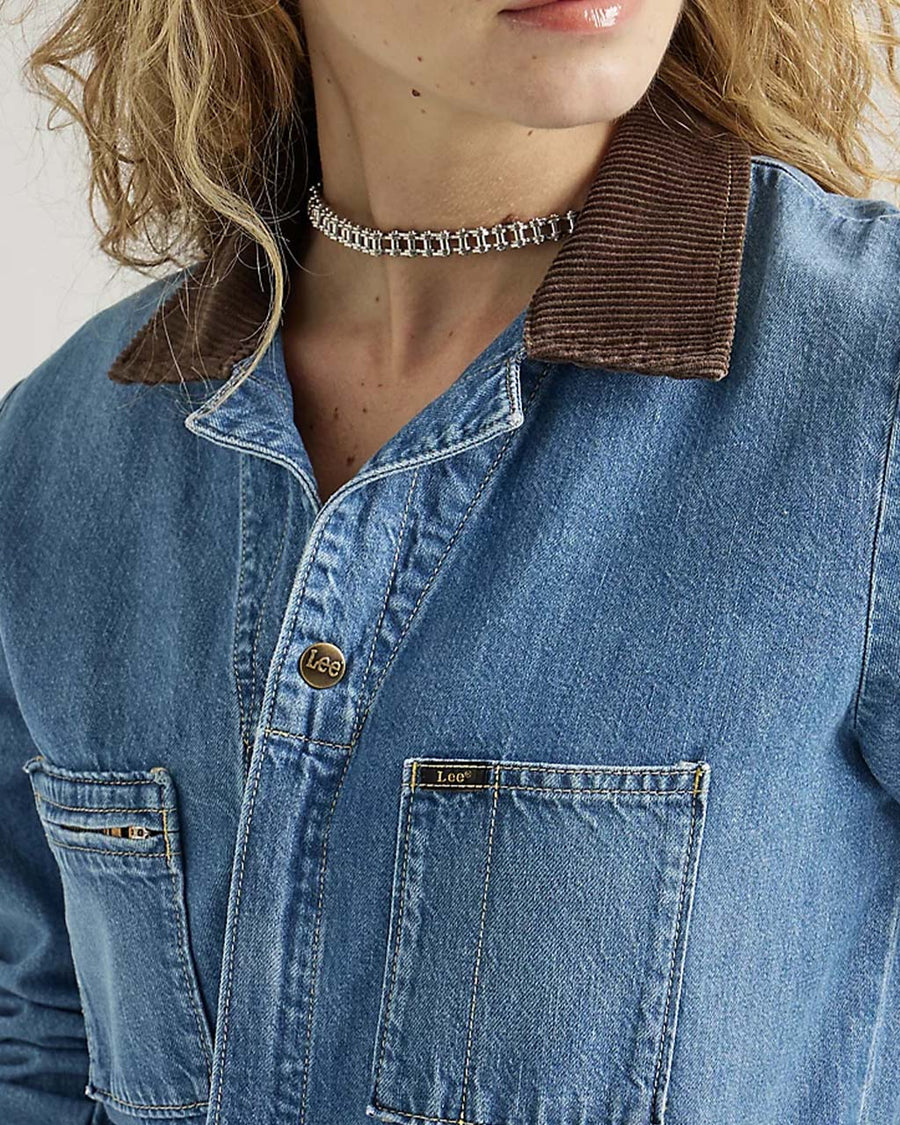 up close of model wearing denim union-all with zipper front and brown corduroy collars