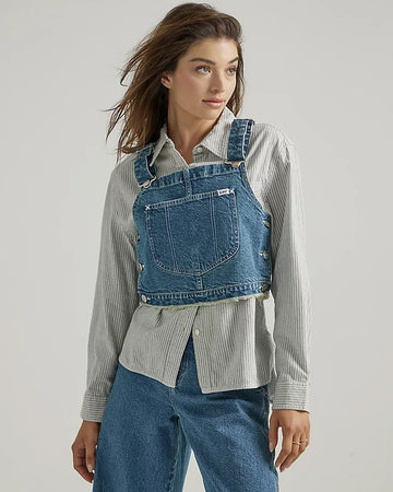 model wearing denim overall bib top with adjustable straps, cropped length and front pocket
