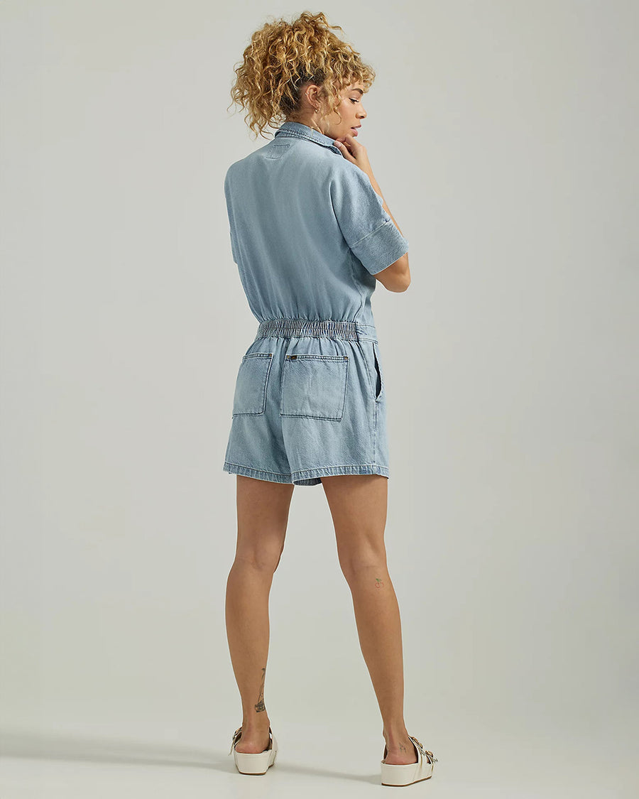 backview of model wearing light blue denim unionall with elastic waist and patch back pockets