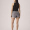 back view of model wearing washed black shorts with frayed hem