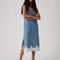 model wearing light denim slip dress with side slits and scalloped lace hem