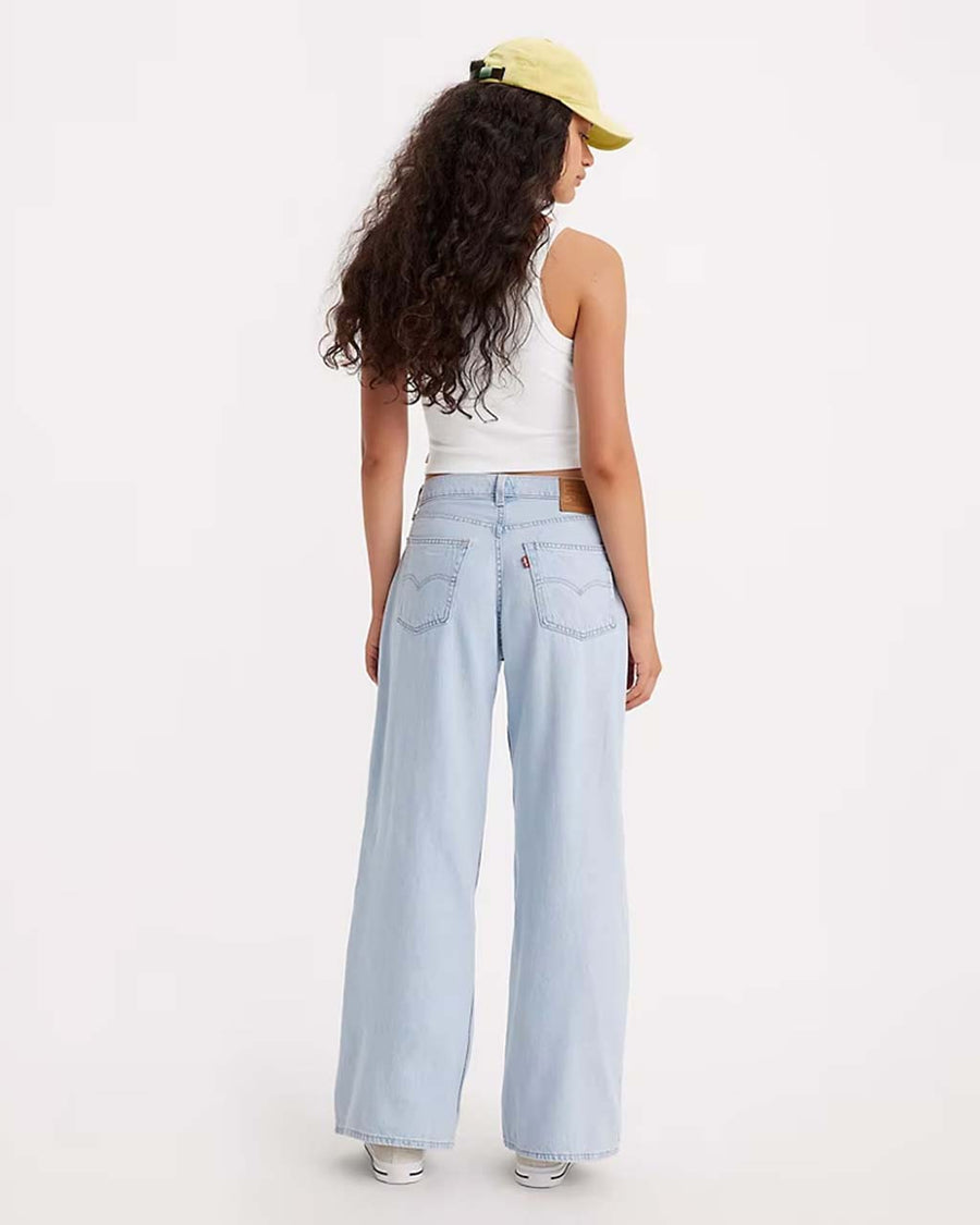 back view of model wearing light denim jeans with oversized baggy look