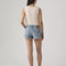 back view of model wearing light denim low rise shorts with distressed hem