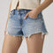 up close of model wearing light denim low rise shorts with distressed hem