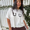 model wearing white cropped relaxed fit tee with black horseshoes on the bust