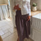 model wearing brown striped midi skirt with asymmetrical detail on the waist