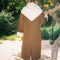 back view of model wearing brown oversized trench coat with white and dainty blue folk print tie shawl, arm and hem trim