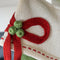 up close of bow detail on green and white stripe cotton stocking with cream cuff, red box and red dot detail
