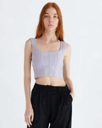 model wearing lavender structured sleeveless crop top with piping detail.