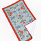 flattened blue tea towel with colorful folk floral print and red trim