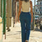 model walking while wearing high waisted dark denim flare jeans