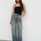 model wearing blueish-green low rise wide leg denim and black tank