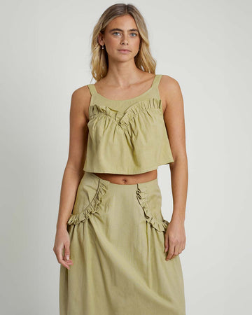 model wearing moss cropped linen tank with ruffle bust detail and matching midi skirt