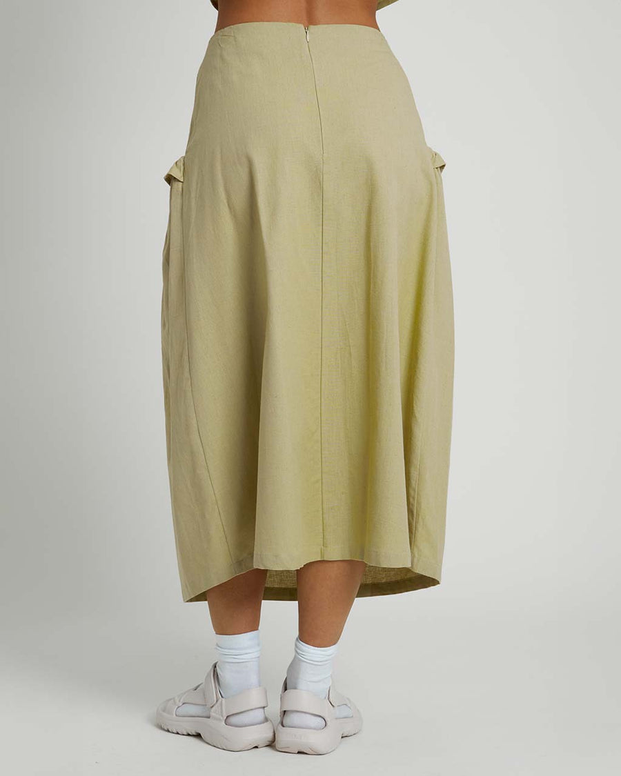 back view of model wearing moss midi skirt with rounded ruffle detail on the hips