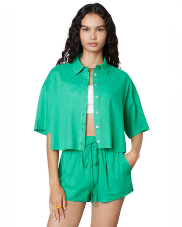 model wearing kelly green linen cropped button down top and matching shorts
