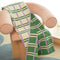 cream towel with kelly green and lilac stripes (and the reversible side is green with cream and lilac stripes) folded on a pink chair