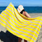 model holding yellow towel with lavender stripes on the beach