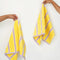 model holding set of two yellow hand towels with lavender stripes