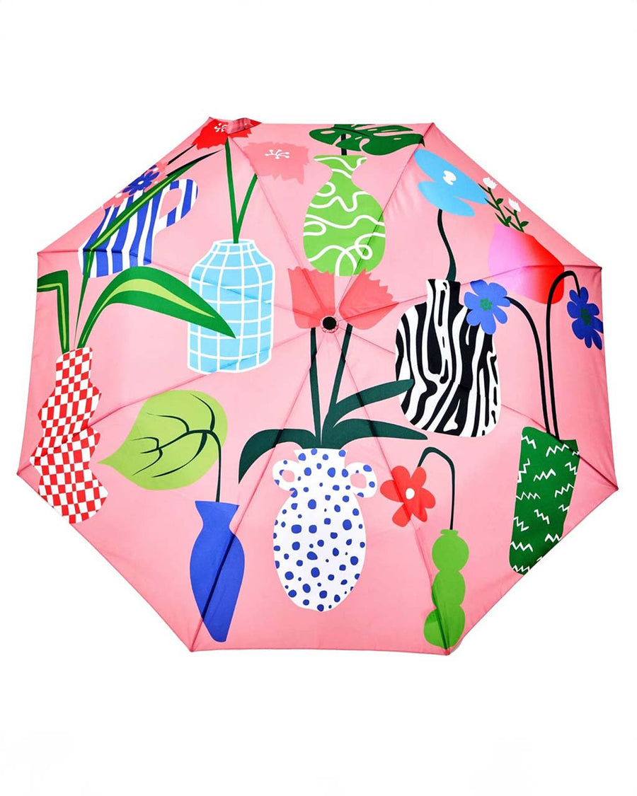 opened pink compact umbrella with abstract vase print and wooden duck head handle