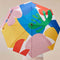 top view of model holding white compact umbrella with wooden duck head handle and colorful abstract shape print