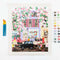 painted paint by numbers kit with periwinkle city image, paint brushes and pots of paint