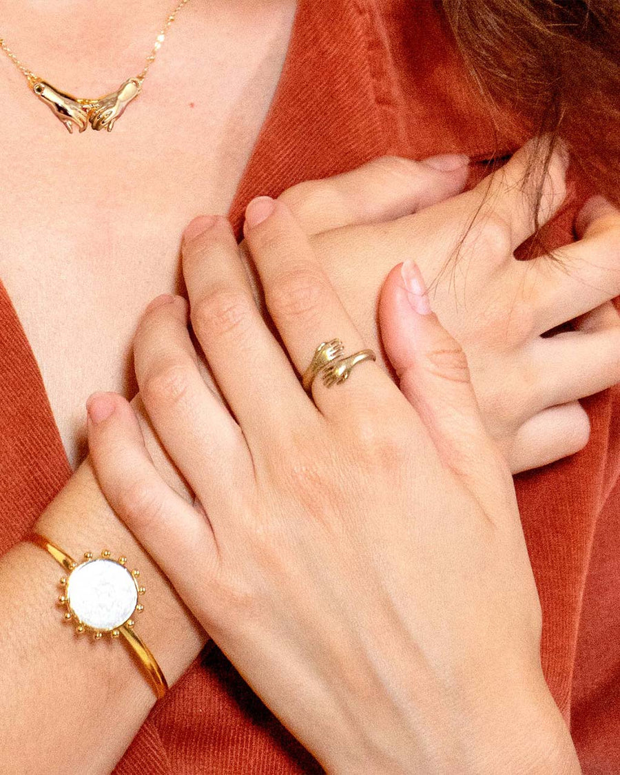 model wearing small gold hands ring