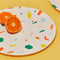 cream dinner plate with colorful confetti print with an orange on it