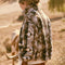 back view of model wearing brown and white geometric zip up sherpa sweatshirt with faux leather trim