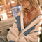 model wearing cream sherpa jacket with blue denim pockets and trim with a high neck collar