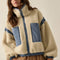 model wearing cream sherpa zip-up jacket with blue denim trim with a high neck collar