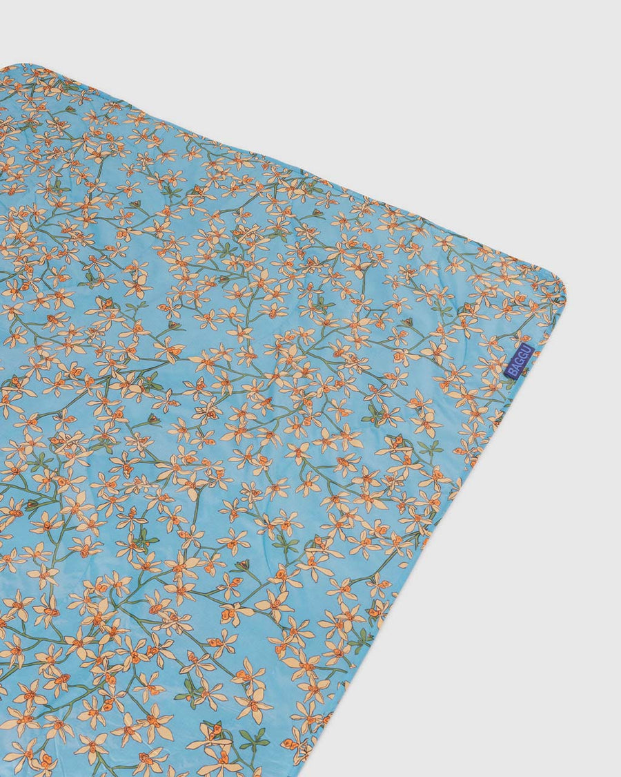 blue puffy picnic blanket with yellow orchid print