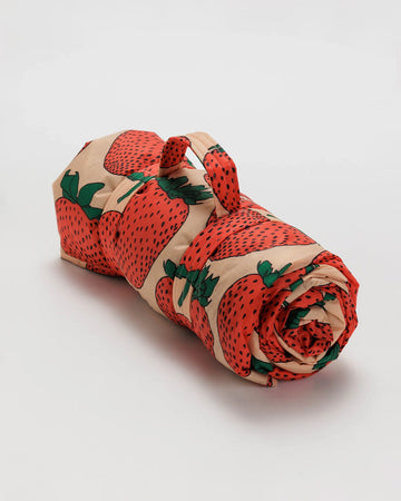 rolled pink puffy picnic blanket with large strawberry print