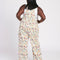 back view of model wearing white overalls with colorful delicate floral print