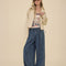model wearing dark blue denim wide leg pants with drawstring waist, elastic waist and raw hems