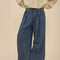 bottom view of model wearing dark blue denim wide leg pants with drawstring waist, elastic waist and raw hems