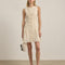 model wearing cream lace mini dress with faux button front detail