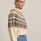 side view of model wearing cream soft sweater with brown and tan nordic print