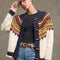 model wearing opened cream toggle front cardigan with brown, yellow, navy, and raspberry nordic pattern