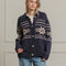 model wearing navy oversized collared cardigan with white snowflake print and patch pockets