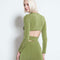 back view of model wearing green criss-cross long sleeve top with matching slinky skirt