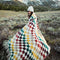 model wearing colorful trippy checkered throw blanket