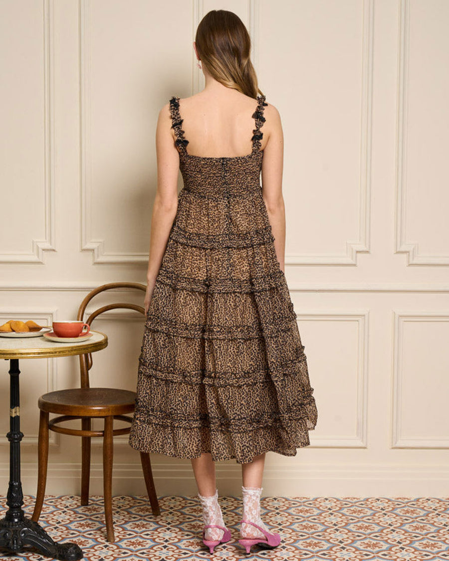 back view of model wearing leopard midi dress with ruffle tiers and black bow detail on straps