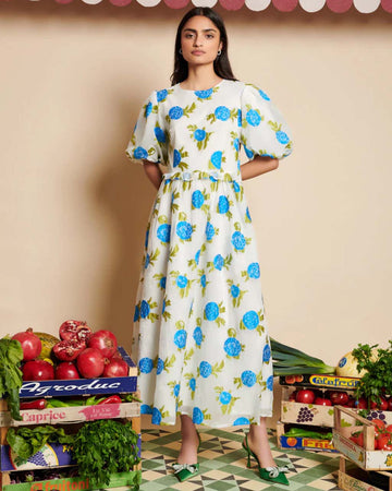 model wearing white jacquard midi dress with all over blue floral print