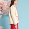 side view of model wearing natural jacket with red ric rac trim and embroidered heart detail on front patch pockets